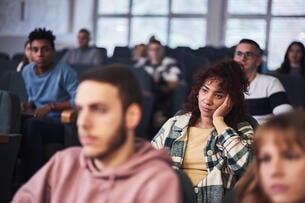 Bored student attending a class in amphitheater.