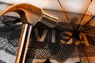 An illustration of a hammer smashing a visa.