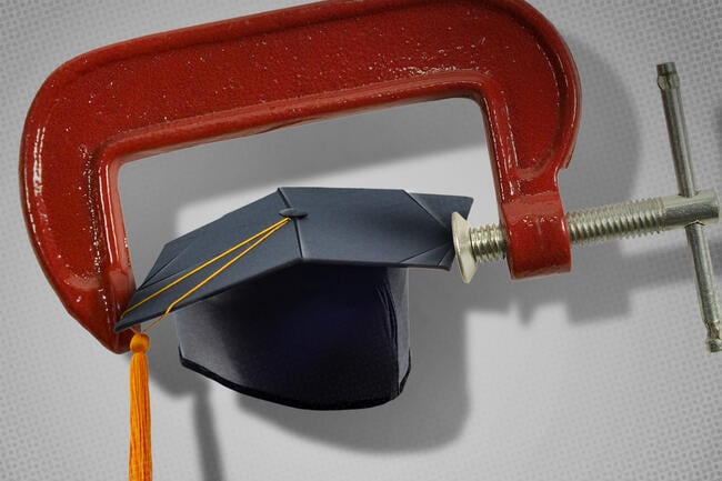 A graduation hat inside of a vise.