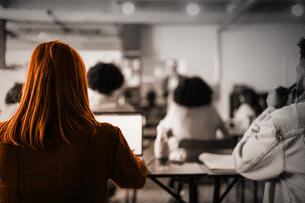 A student on a computer during a college lecture