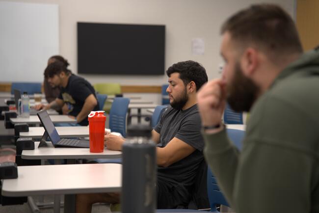 Four students work at their desks during a class period. 