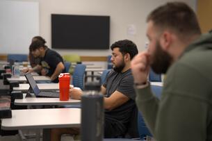 Four students work at their desks during a class period. 