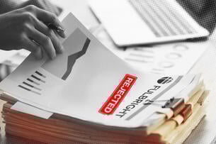 A illustration of a person looking at research paper with a "Fulbright" header and a "rejected" stamp on it.