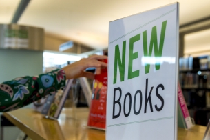 A sign reading "New Books" is displayed at a library.