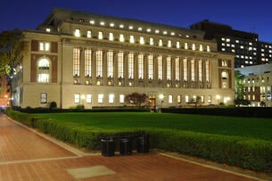 A photo of Butler Library on Columbia University’s campus, lit up at night.
