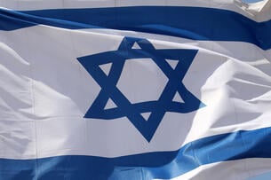 A photo of an Israeli flag fluttering.