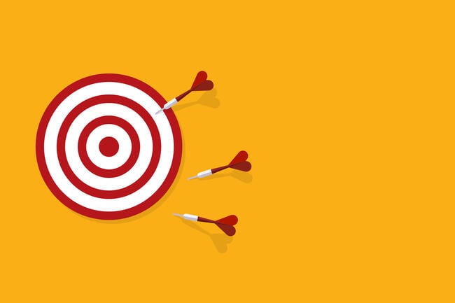 Three darts miss the bullseye on a target