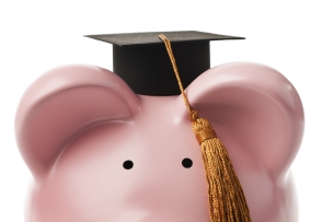A close-up of a piggy bank wearing a small graduation cap