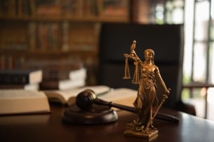 Scales of justice in front of a legal textbook