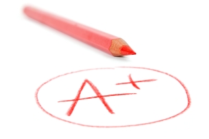 An A-plus grade, written and circled in red, against a plain white background, with a red colored pencil lying alongside it.