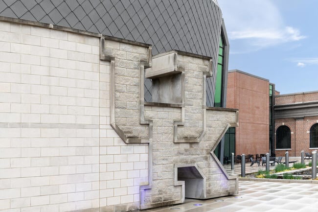 A photo of the brick side of a building with brick letters spelling out "UK," the University of Kentucky logo.