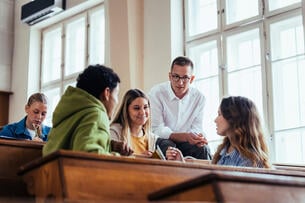 A group of four college students engages in a group discussion.
