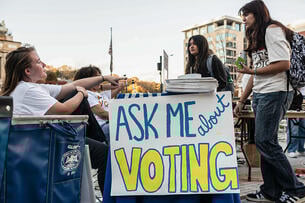 University of Pittsburgh students stand near a sign that says "Ask Me About Voting."