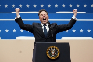 Elon Musk with fists raised behind a podium at Trump's inauguration.
