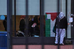 Students with a Palestinian flag seen through window at Barnard College library.