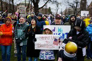 Protesters hold signs including "Harvard: Protect International Students" and "Stand Up to Bullies!" during a Cambridge Common rally.