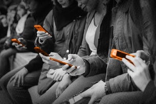 Students sitting on a bench all on their cell phones.