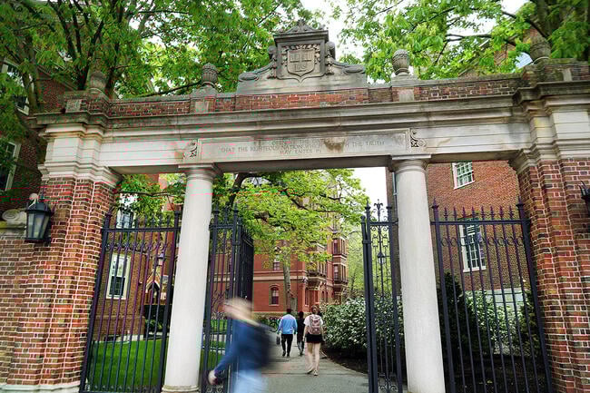 People enter Harvard Yard through a gate.