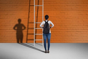 A student stands in front of a ladder with a couple of missing rungs.