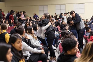 A large group of students, in which some are hugging