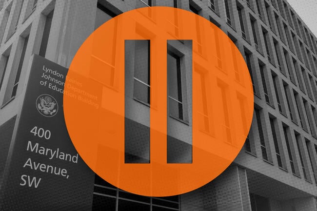 A pause symbol over the Department of Education building.