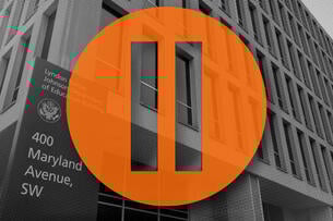 A pause symbol over the Department of Education building.