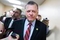 Rep. Tom Cole, a light-skinned man with gray hair wearing a blue suit, talks with reporters after a meeting of the House Republican Conference in the U.S. Capitol.