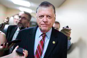 Rep. Tom Cole, a light-skinned man with gray hair wearing a blue suit, talks with reporters after a meeting of the House Republican Conference in the U.S. Capitol.
