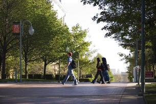 Students walking behind Old Main building on the campus of the University of Arkansas.