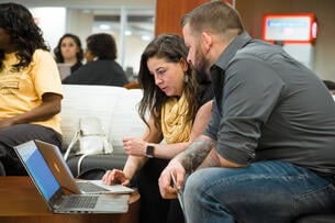 Two adult learners at Wichita State University in Kansas work on their laptops.