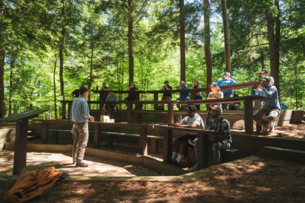 A group of adults sit at an outdoor amphitheater at Paul Smith's College in New York